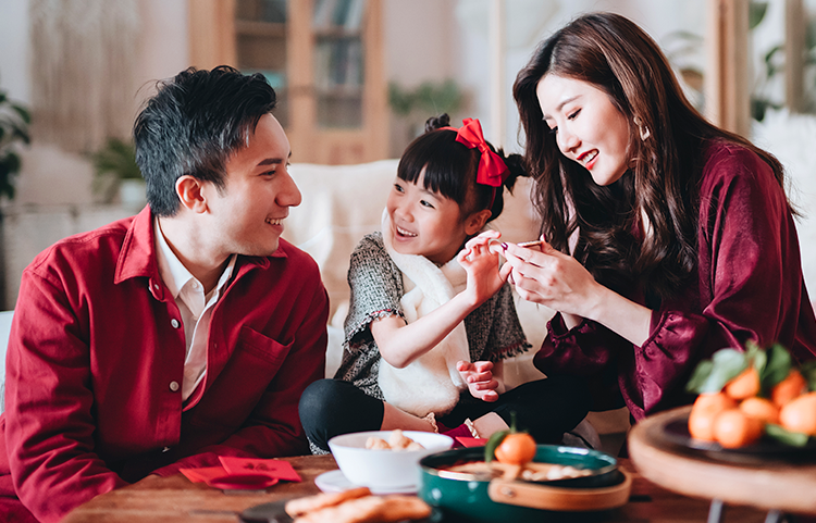Asian family eating snacks and celebrating the Lunar New Year.